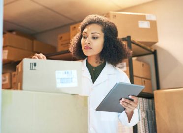 Shot of a young woman using a digital tablet while doing inventory in the storeroom of a pharmacy